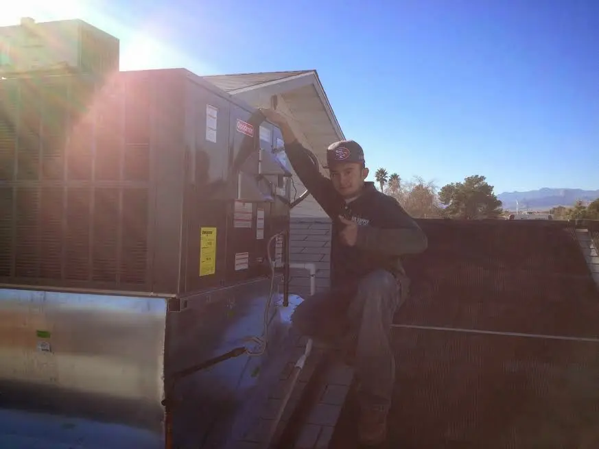 HVAC technician performing Heat Pump Repair on a rooftop unit in Bethany